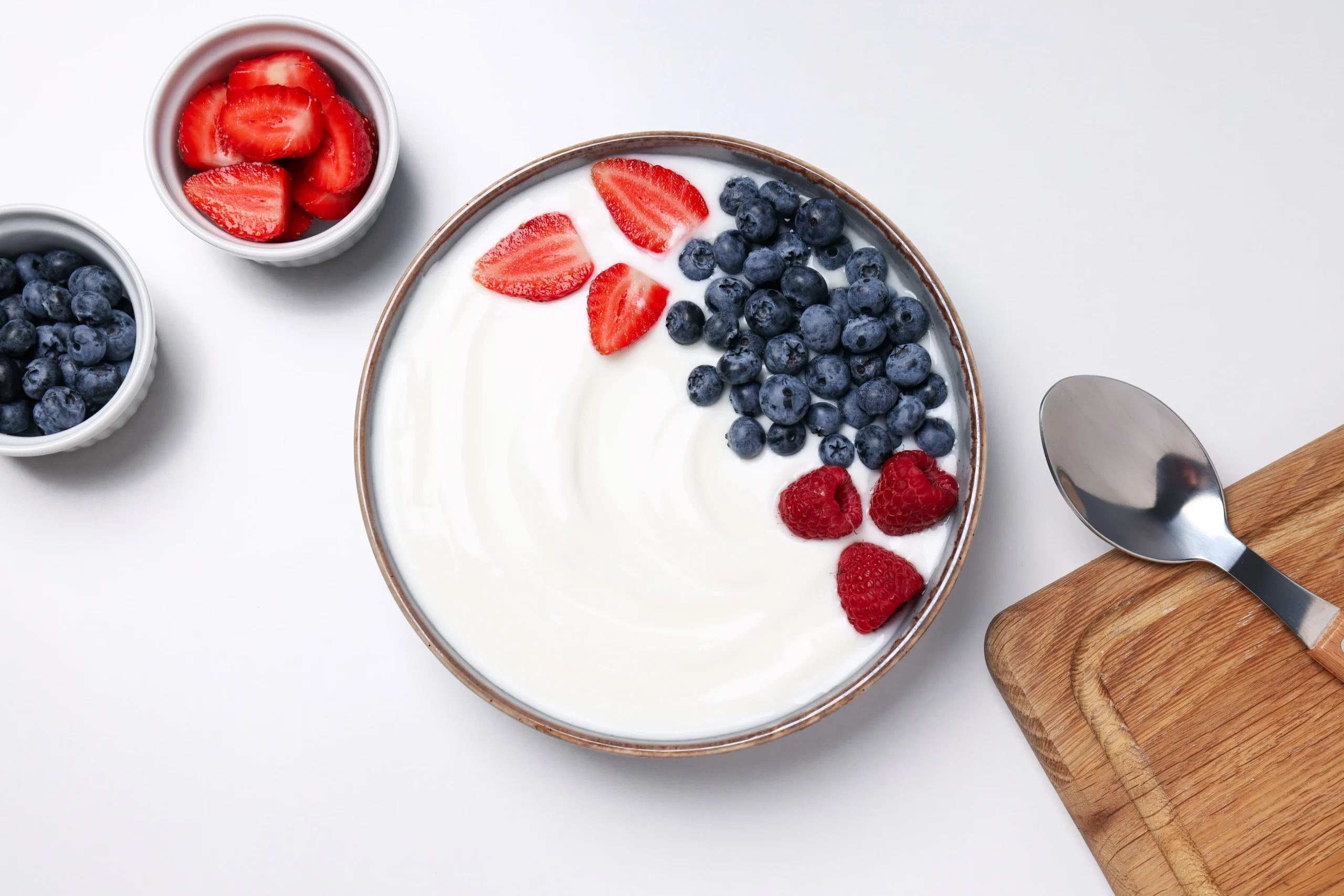 bowls-with-yogurt-and-berries-spoon-and-board-on-2025-03-25-03-19-38-utc