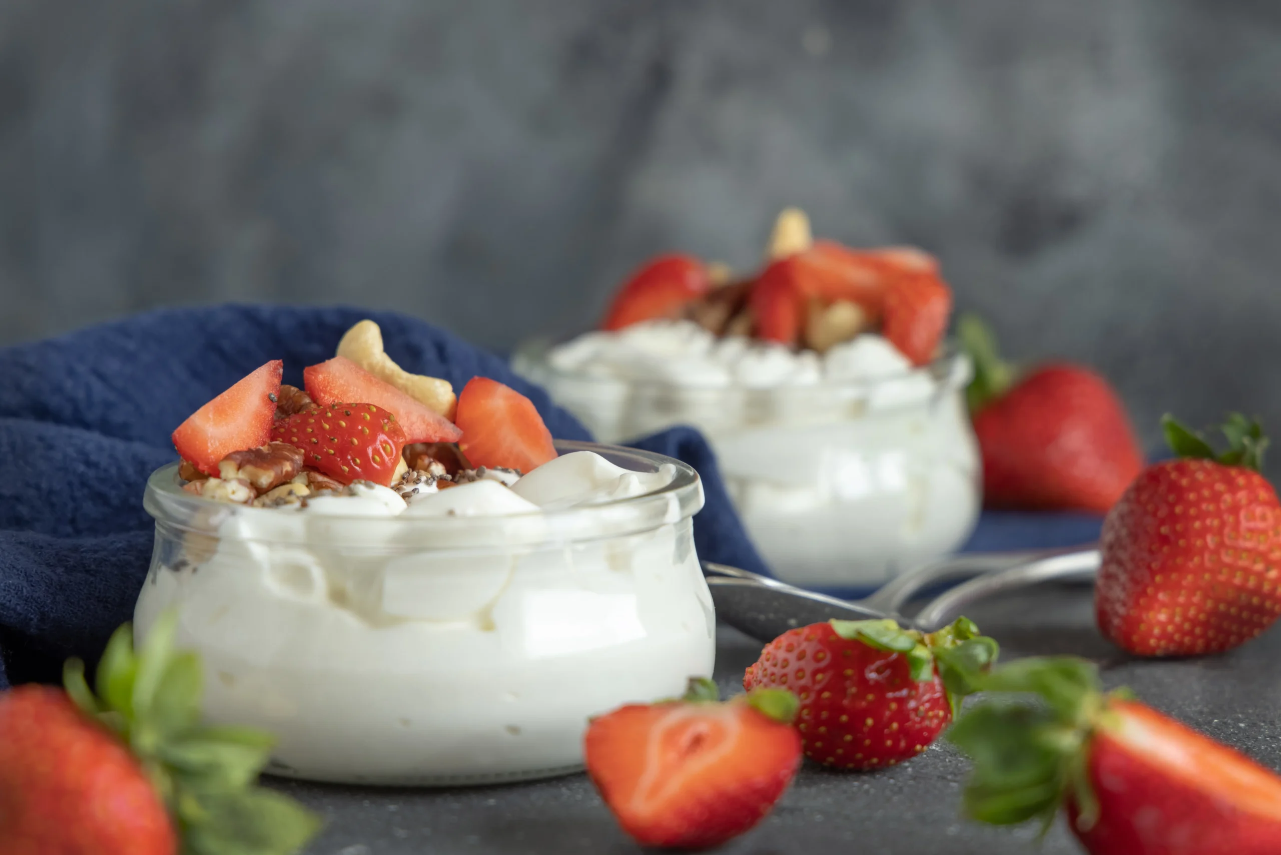glass-jars-of-yogurt-nuts-and-strawberries-on-gre-2025-03-28-06-49-45-utc